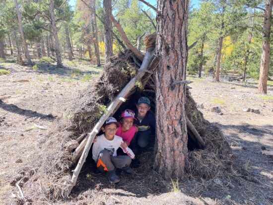 Three kiddos in their debris shelter