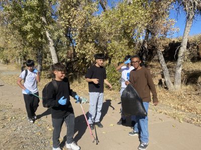 AXL students are picking up trash near their school as an action project during CAP class.