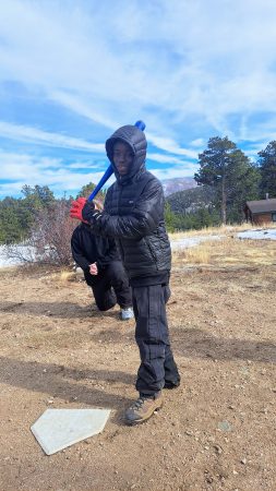 An AXL Academy 8th grader stands at bat during a game of baseball