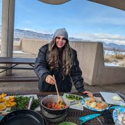 A RiseUp student cooks on a camp stove