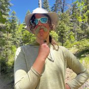 A student poses with a plant as a moustache