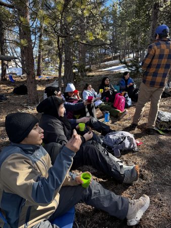 Students experience nature connection and connection with each other as they take a break from quinzhee building to have pizza, tea, and dessert.