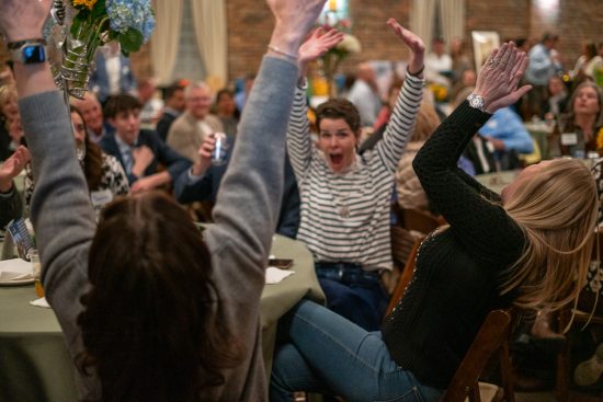 Base Camp Bash attendees celebrate their win in the live auction at the event celebrating 20 years of Cottonwood Institute.