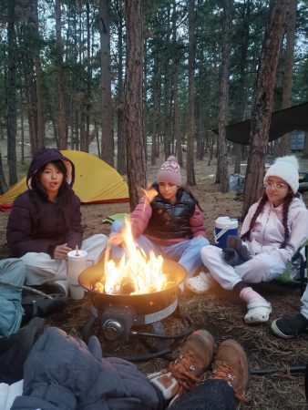 AXL Academy students enjoy the campfire after they tried archery earlier in the day.
