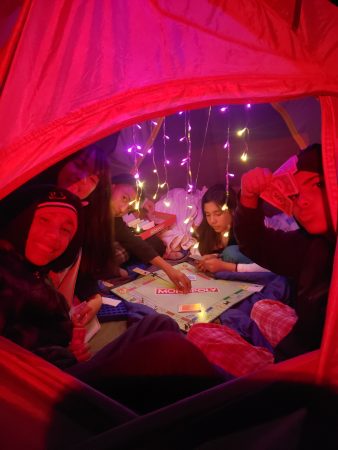AXL students enjoy playing board games in the tent after a day that included archery as well.