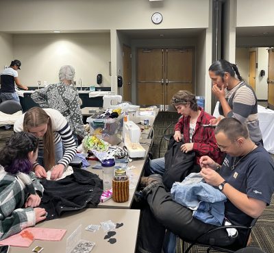 Changemaker students repair outdoor gear at the gear repair workshop they hosted at the Lafayette Library.