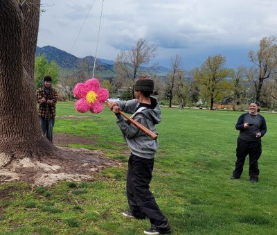 A Centaurus High student attempts to hit a flower-shaped pinata with a bat.