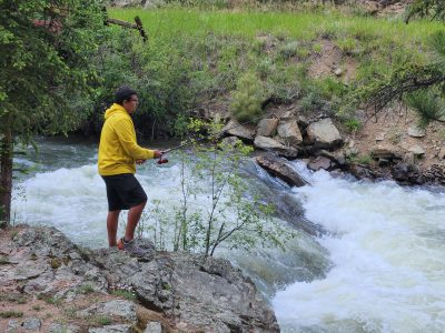 A Longmont Youth Center student fishes in a stream during the overnight camping trip.