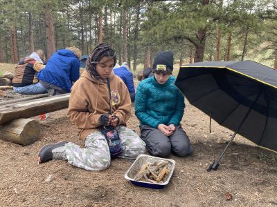 NVHS students learn fire-building skills during a break in the wet weather that included rain-snow mix.
