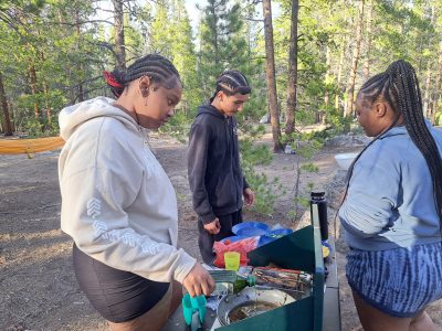 RiseUp students learn how to prepare meals on camp stoves during their week-long water-focused expedition.