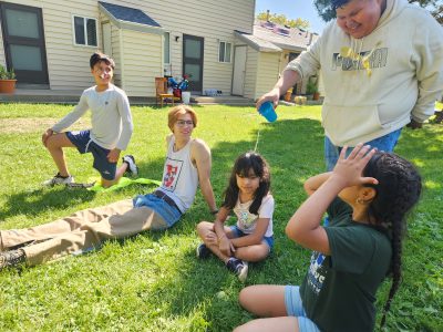 Casa participants play a game that involves pouring water on others' heads.