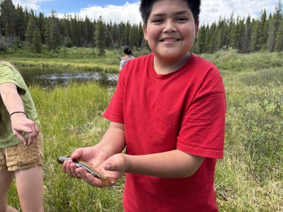 A student shows off a fish he caught during the DSST/LHC Watershed program.