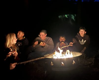 LYC students make s'mores over the campfire before testing their night vision with Skittles on a night hike.
