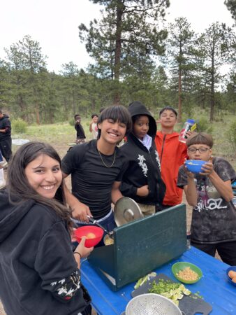 DMLK students enjoy making meals together with the camp stove.