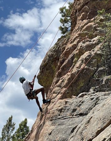 A DMLK student learns rock climbing during their week of outdoor learning.