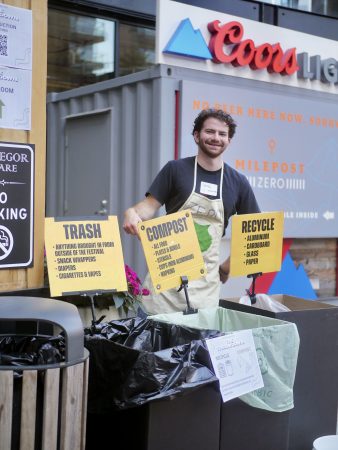 A Cottonwood staff member poses near the zero waste bins during the 2025 Cottonwood Throwdown cornhole tournament.