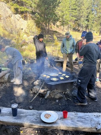 CAP students make French toast over the sparks of the morning campfire on their overnight trip.