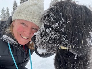 Cottonwood Board member Candace poses in the snow with her dog.